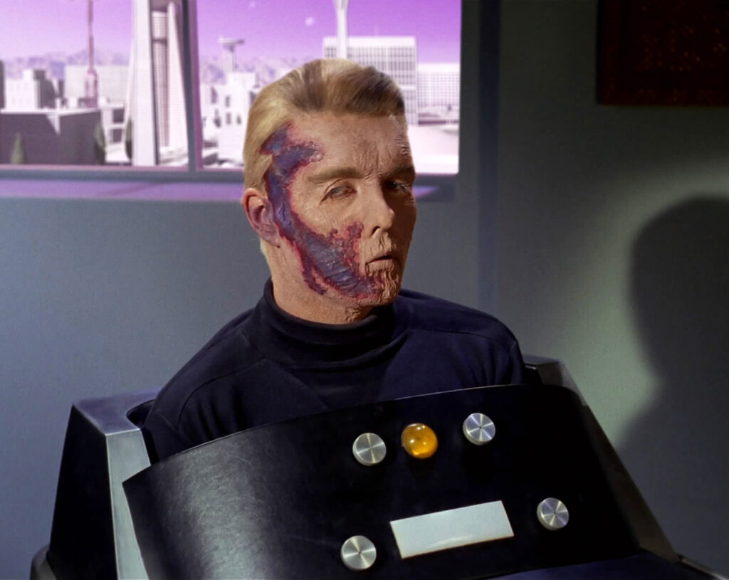Captain Christopher Pike sits in his life-support chair, his face scarred by radiation injuries, in “The Menagerie”.