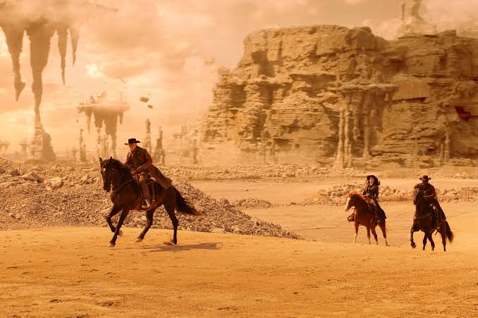 Christopher Pike, La'an Noonien-Singh and Dr. Joseph M'Benga ride horses through a dessert area dressed like cowboys from Star Trek: Strange New Worlds season four episode one Valles Marineris.